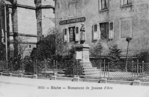 Au pied de l'église Sainte-Catherine, la statue de sainte Jeanne d'Arc veille sur la cité fortifiée. Ici photogaphiée au début du siècle, elle se situait devant le " café Jeanne d'Arc ", qui a été détruit dans les années suivant la dernière guerre.