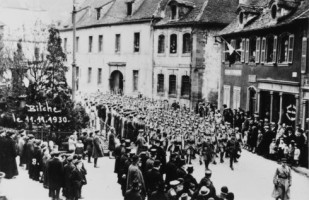 Cérémonie patriotique devant le monument aux morts situé aux pieds de l'église catholique, le 11 novembre 1930.