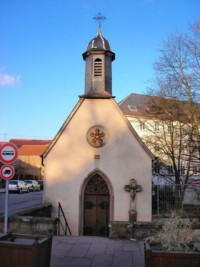 La croix est désormais adossée à la façade de la Weiherkapelle de Bitche.