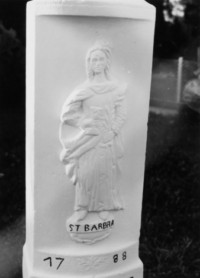 La sculpture en bas-relief de sainte Barbe occupe le fût-stèle (photographie du service régional de l'inventaire de Lorraine).