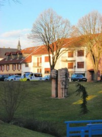 La sculpture moderne située au centre du parc, sur les bords de la Horn, et les toits de l'ancien hôpital Saint-Joseph en arrière-plan.