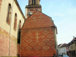 Une belle maison ancienne se situe à proximité immédiate de l'église Sainte-Catherine, entre la nef de celle-ci et la rue du Maréchal-Foch. Le monument commémoratif est situé contre le mur Nord de la nef, donnant sur cette rue.