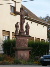 En bordure de la grande rue de Haspelschiedt, le calvaire appelé localement croix Keller présente la Très Sainte Vierge Marie et saint Jean, traités en ronde-bosse, qui entourent le croisillon.