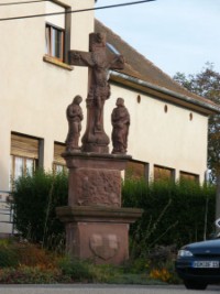 En bordure de la grande rue du village de Haspelschiedt, le calvaire appel localement croix Keller est rige en 1758 et restaur en 1863. Un haut pidestal de plan rectangulaire supporte une stle orne d'une Vision de saint Hubert, un peu fruste, sculpte en bas relief,  laquelle assiste, comme souvent dans le pays de Bitche, le trs populaire saint Wendelin agenouill au milieu de ses moutons. La Trs Sainte Vierge Marie et saint Jean, traits en ronde-bosse, ainsi que Notre-Seigneur Jsus-Christ en croix s'imposent par la qualit inhabituelle de la sculpture et par le traitement savant du perizonium (linge ceignant Notre-Seigneur  la taille). Un calvaire semblable, datant de la mme poque, se dresse dans le cimetire du petit village voisin de Liederschiedt.