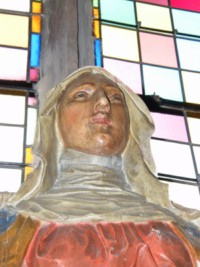 Le visage serein de la Sainte Vierge Marie est encadré par un petit voile court.