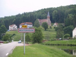 L'entrée du village de Mouterhouse est dominé par la silhouette de l'élégante église catholique Saint-Jacques (photographie de la com. de com. de Bitche et environs).
