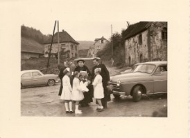 Cette photographie restitue l'arrivée de la première pierre de la nouvelle église. On peut reconnaître le jeune abbé Nullans avec sa sacoche, ainsi que Monseigneur Louis, vicaire général du diocèse ; le maire de l'époque, Lucien Schneider, est aussi présent ; les trois jeunes filles sont Yvette Steiner née Seiler, Laurette Knebel née Tarral, la fille de l'insituteur de l'époque, et Liliane Duquesne née Lang.