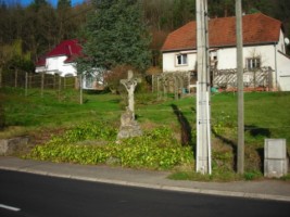 La croix est érigée en bordure de la rue principale, au niveau de l'ancien moulin.