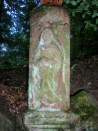 La Vierge du Calvaire est représentée sur la partie supérieure du fût.