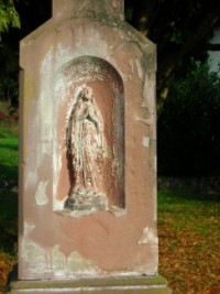 Une représentation de la Sainte Vierge figure sur le fût de la croix.