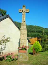 La croix monumentale située dans la rue de l'église, à l'arrière du presbytère.