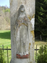 La Très Sainte Vierge est représentée au milieu du fût-stèle.