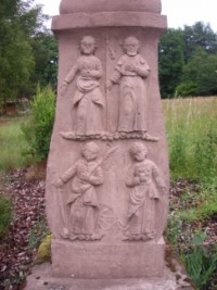 Quatre saints sont représentés sur la face du fût-stèle, répartis en deux registres.