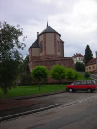 Le chevet de l'église Saint-Rémi : l'édifice occupe tout l'espace disponible sur le plateau gréseux qui émerge dans la vallée.