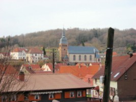 L'église paroissiale Saint-Rémi, l'ossuaire du XIIe siècle et le presbytère sont visibles depuis la grotte de Lourdes, qui se situe un peu à l'écart de la localité de Schorbach.