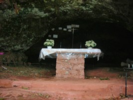 Un autel est érigé dans la grotte de Lourdes.