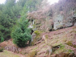 La réplique de la grotte de Lourdes est aménagée dans une paroi rocheuse naturelle de grès rose.