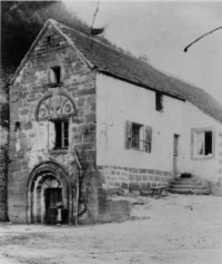 Vestiges de l'église abbatiale avec le tympan roman remployé, au début du XXe siècle, d'après une photographie conservée aux archives départementales de la Moselle, dans le fonds Morhain.