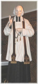 Une statue du saint Curé d'Ars est installée au pied de l'autel latéral droit.