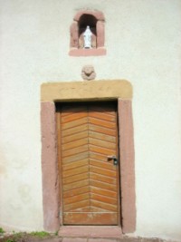 L'entrée de l'ermitage, qui porte la date 1745 sur le linteau, est surmontée d'une tête d'angelot ainsi que d'une statue de la Sainte Vierge.