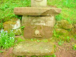Le socle de la croix représente le très populaire saint Wendelin, fortement dégradé par l'érosion.