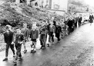 Des écoliers en chemin vers l'église avant la guerre.