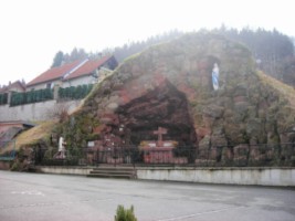 La réplique de la grotte de Lourdes se situe à gauche de l'entrée de l'église.