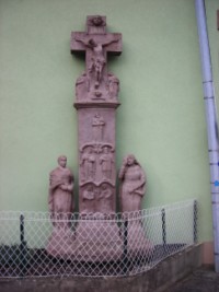 Une croix monumentale est adossée à la façade latérale de la maison numéro 16, rue d'Alsace.