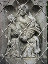 Notre-Dame de Pitié est représentée sur le fût de la croix, s'inspirant de la statue conservée au presbytère.