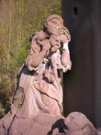 Une statue de sainte Marie-Madeleine est située sur le socle de la croix : essuyant ses larmes, elle est agenouillée aux pieds de son Seigneur et Maître.