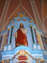 Une statue du Sacré-Cœur de Jésus trône dans une grande niche aménagée au-dessus du tabernacle du maître-autel.