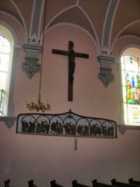 La frise du chemin de croix, figurant sur le mur gauche de la nef, est surmontée d'une croix d'applique.