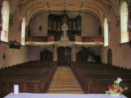 Vue intérieure de l'église, vers la tribune et l'orgue : la " pierre noire " est située à l'extrême gauche.