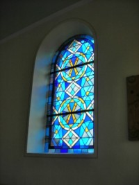 Des vitraux géométriques bleus ont été installés dans la première chapelle du sanctuaire.