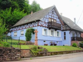 La croix érigée en bordure de la route principale, après son déplacement dans le jardin d'une maison de la Grande-Rue.