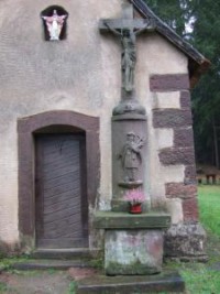 Une croix est adossée à droite de la porte de la Pauluskapelle.