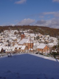 Le centre du village de Soucht, l'église de l'Assomption de la Sainte Vierge et le cimetière sous la neige.