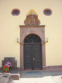 La porte de la chapelle et le fronton sculpté datant du XVIIIe siècle.