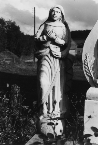La statue de la Très Sainte Vierge, sculptée en ronde-bosse, se situe au pied du calvaire (photographie du service régional de l'inventaire de Lorraine).