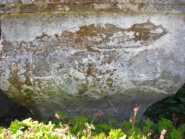 Un cœur rayonnant, entouré d'une guirlande végétale, occupe toute la surface du socle.