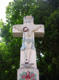 Deux têtes d'angelots ailées dominent le croisillon de la croix.