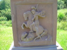 Saint Georges, patron des soldats, est représenté sur le fût-stèle, terrassant le dragon de son épée.