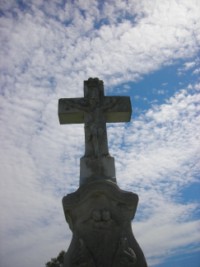 Le croisillon de la croix est lui aussi dominé par deux têtes d'angelots ailées.