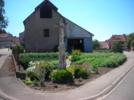 La croix se dresse au croisement de la rue de l'école et de la rue du moulin.