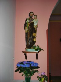Une statue en plâtre de saint Joseph portant l'Enfant-Jésus est située à gauche de l'arcade séparant la nef du chœur.