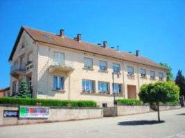 Le bâtiment de la mairie-école se situe à proximité de l'église paroissiale Saint-Donat.