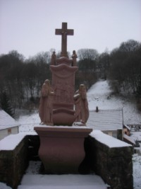 Un calvaire, érigé à Lengelsheim au début du XIXe siècle, présente les statues sculptées en ronde-bosse de la Très Sainte Vierge et de saint Jean, posées sur le socle, encadrant le fût-stèle.