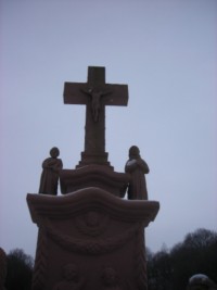 Le croisillon est entouré des statues en ronde-bosse de saint Joseph et de saint Antoine de Padoue.