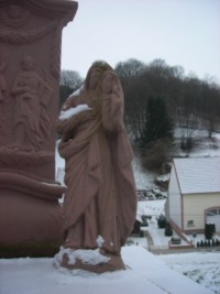 Une statue en ronde-bosse de la Sainte Vierge se situe à droite du fût.