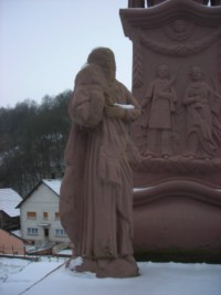 Une statue en ronde-bosse de saint Jean se situe à gauche du fût.